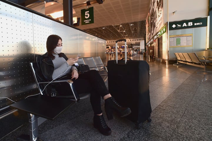 Una mujer espera en el aeropuerto de Malpensa, Milán (Italia).