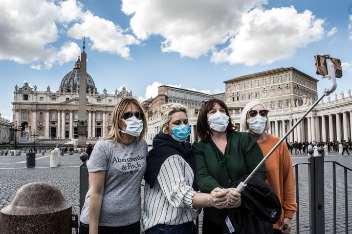 バチカンのサン・ピエトロ広場で、マスクをして自撮りする旅行者たち / 3月8日