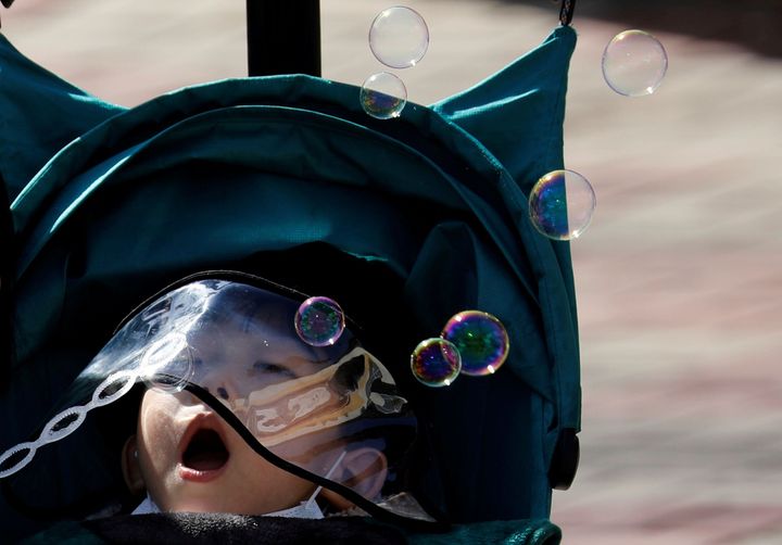 新型コロナウイルスの感染者が急増した、韓国の大邱。幼い子どもが防護スクリーン付きの帽子を被ってシャボン玉を飛ばしていた / 3月12日