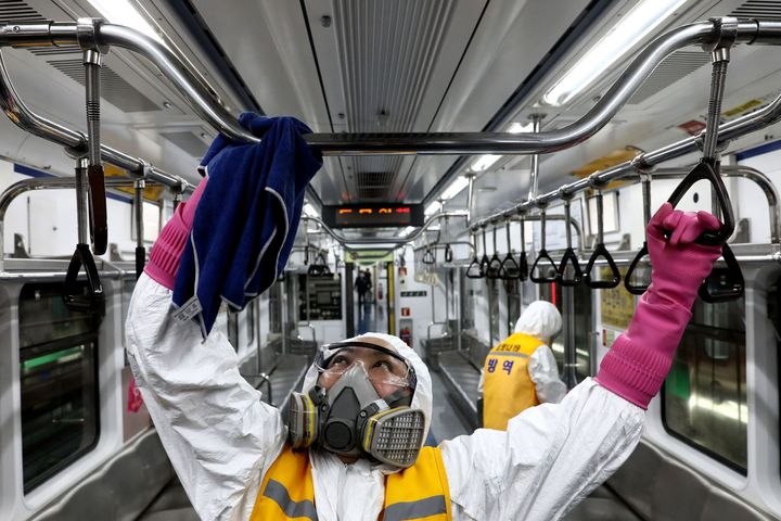 こちらは韓国・ソウル。防護服を着た作業員が地下鉄の車両内に消毒液を散布している / 3月11日