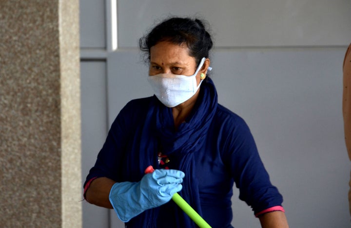 A railway worker wears face mask as a preventive measure against coronavirus, as she cleans the railway station in Guwahati, Assam, India on March 12, 2020. 