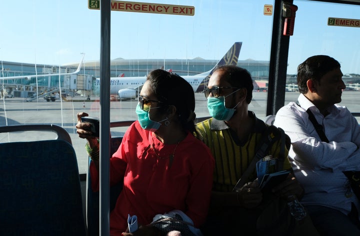 Passengers wearing masks as a precaution against a coronavirus ride a bus at Chhatrapati Shivaji International Airport in Mumbai, March 10, 2020.