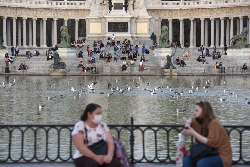 People are seen sunbathing at Retiro park during the corona virus threat in Madrid. 