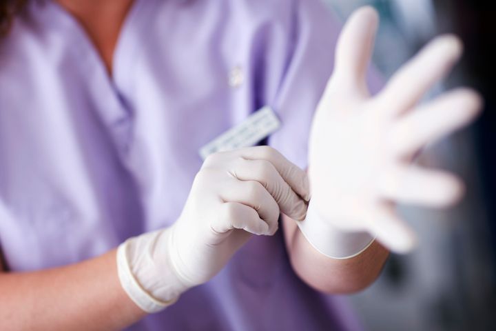 Nurse Putting on Rubber Gloves