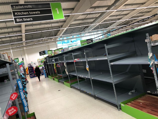 A view of empty shelves as toilet roll and kitchen roll are almost sold out in an Asda supermarket in...