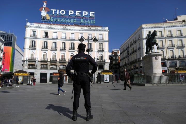 A police officer stands guard at Sol square in downtown Madrid, Spain, Saturday, March 14, 2020.