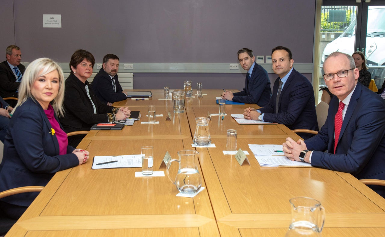 Ireland's Prime Minister, Leo Varadkar (2R), Northern Ireland's First Minister, Arlene Foster (2L), Northern Ireland Deputy First Michelle O'Neill (L) and Tánaiste and Minister for Foreign Affairs and Trade Simon Coveney (R) gesture at the North South Ministerial Council offices in Armagh, Northern Ireland on March 14, 2020, before a meeting of the Irish Government and Northern Ireland Executive concerning the novel coronavirus Covid-19 outbreak. (Photo by Paul Faith / AFP) (Photo by PAUL FAITH/AFP via Getty Images)