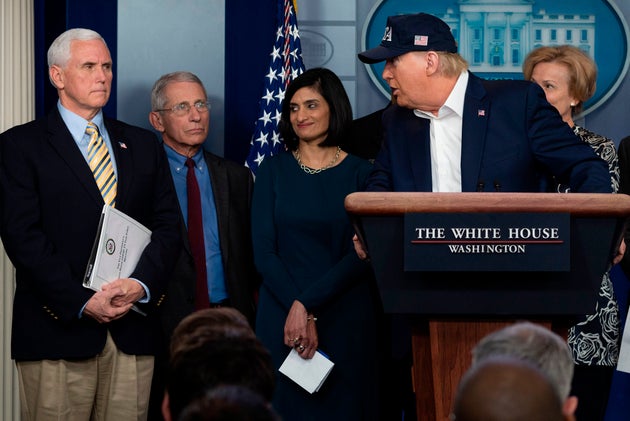 Trump speaks as US Vice President Mike Pence listens alongside members of the Coronavirus Task Force...