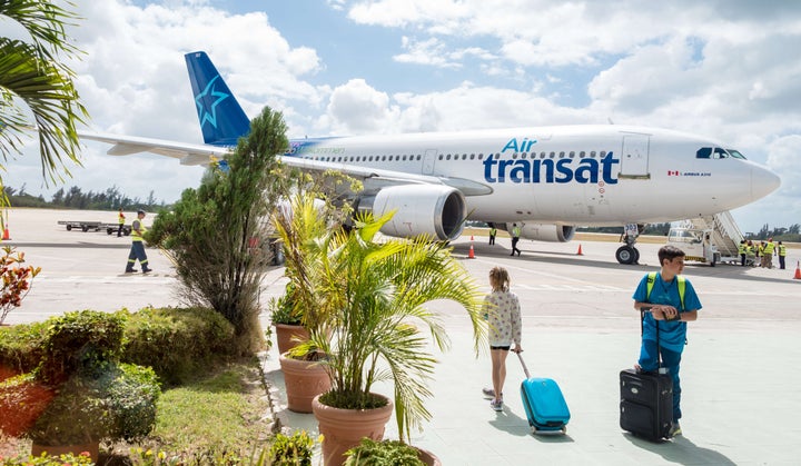 Passengers prepare to board an Air Transat airplane in Cuba on Feb. 19, 2016.