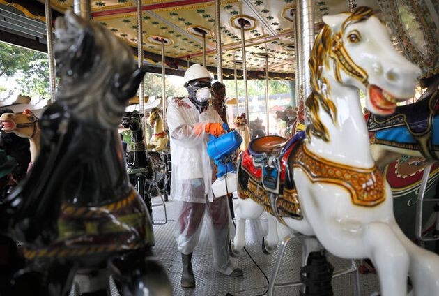 ジャカルタの遊園地で14日、防護服を着て消毒をする職員=AP