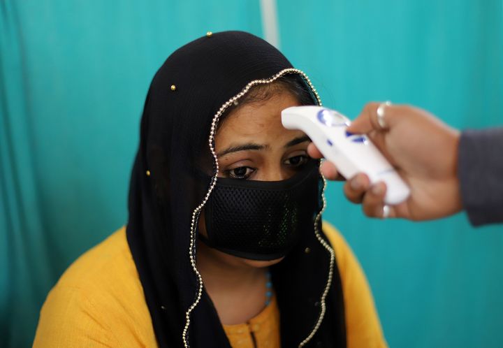 A doctor examines a patient in an area set aside for possible COVID-19 cases during a free screening camp at a government homeopathic hospital in New Delhi. 