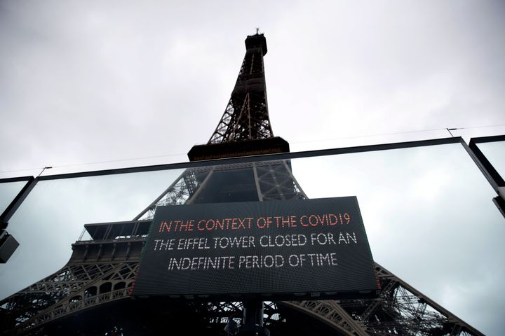 A screen announces the closure of the Eiffel Tower after the French government banned all gatherings of over 100 people to limit the spread of the virus COVID-19, in Paris, Saturday, March 14, 2020. (AP Photo/Christophe Ena)