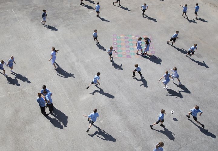 children aged 10-11 running on playground elevated view.