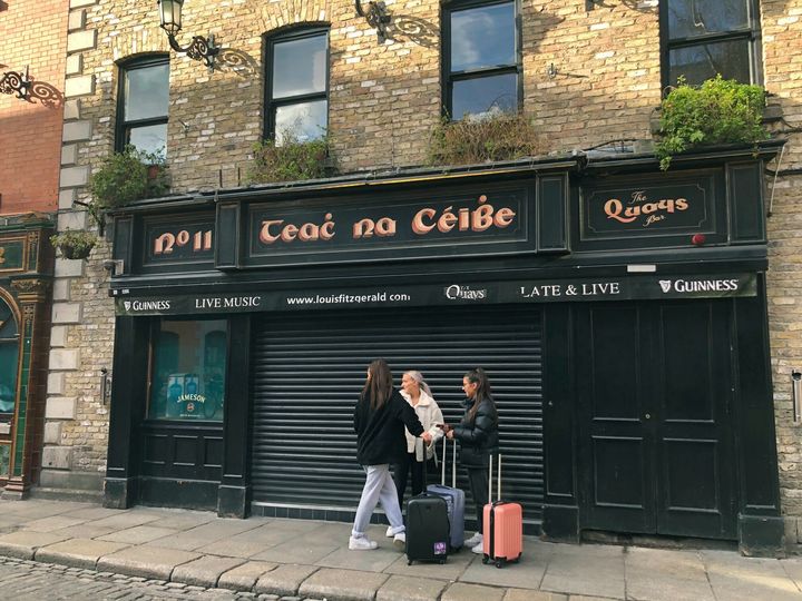 People stand outside The Quays Bar in Dublin as pubs and clubs in the Irish tourist hotspot Temple Bar closed with immediate effect amid coronavirus fears.