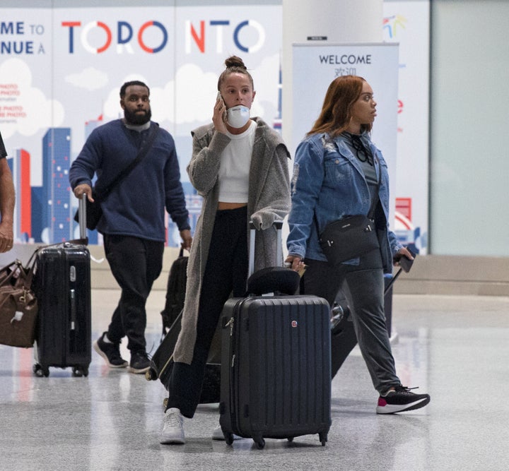 A traveller makes a phone call in the international arrivals lounge at Pearson Airport in Toronto, amid a growing global number of coronavirus March 13.