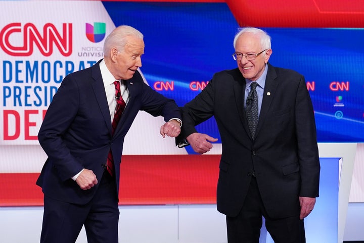 Democratic presidential hopefuls former Vice President Joe Biden and Sen. Bernie Sanders (I-Vt.) greet each other with an elbow bump as they arrive for the Democratic primary debate on Sunday.