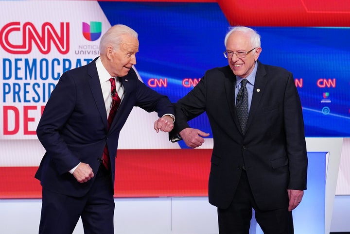Democratic presidential hopefuls former Vice President Joe Biden and Sen. Bernie Sanders (I-Vt.) greet each other with an elb