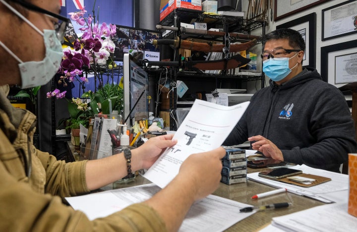 David Liu, owner of a gun store, takes an order from a customer in Arcadia, California, on Sunday.