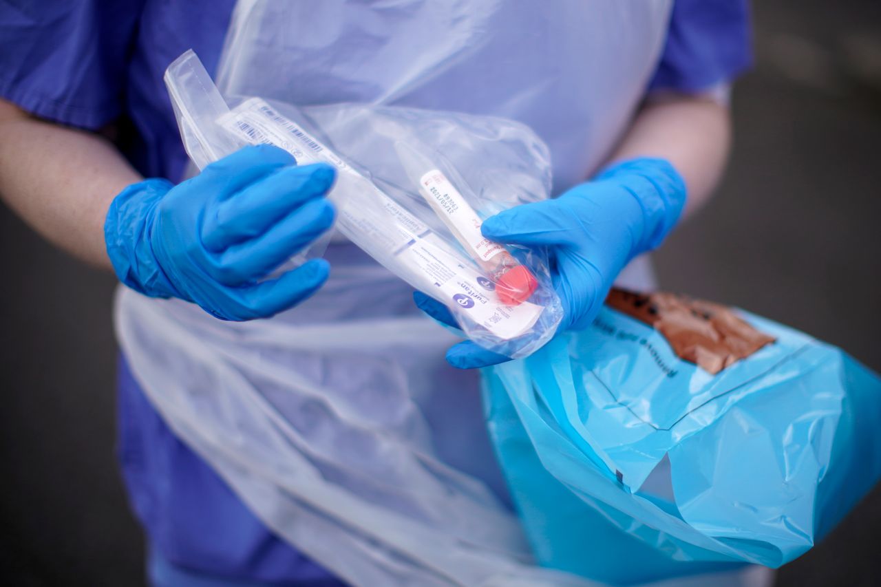 A nurse holds a coronavirus testing kit as she speaks to the media in Wolverhampton