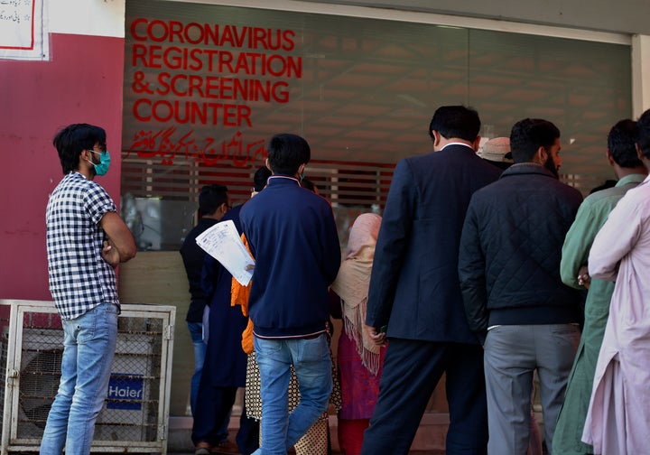 People wait their turn at a coronavirus registration and screening counter at the Pakistan Institute of Medical Sciences Hospital, in Islamabad, Pakistan, March 17, 2020.