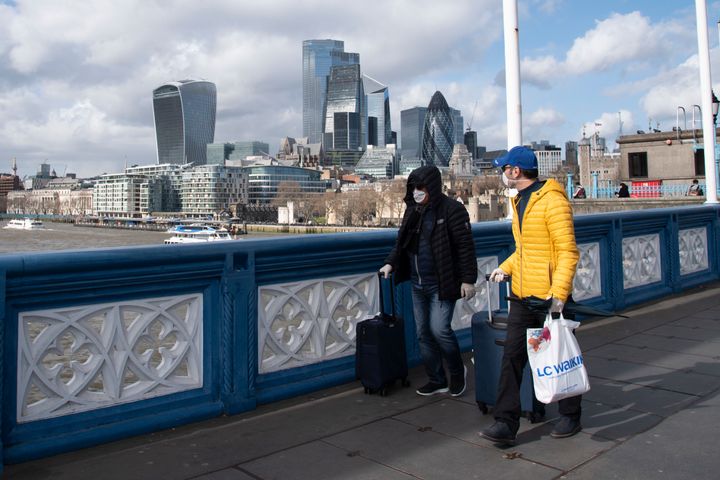 Tourists wear surgical masks on Tower Bridge during the Coronavirus outbreak in London