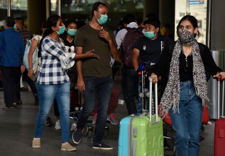 Airline passengers wearing masks at Mumbai airport on Monday.