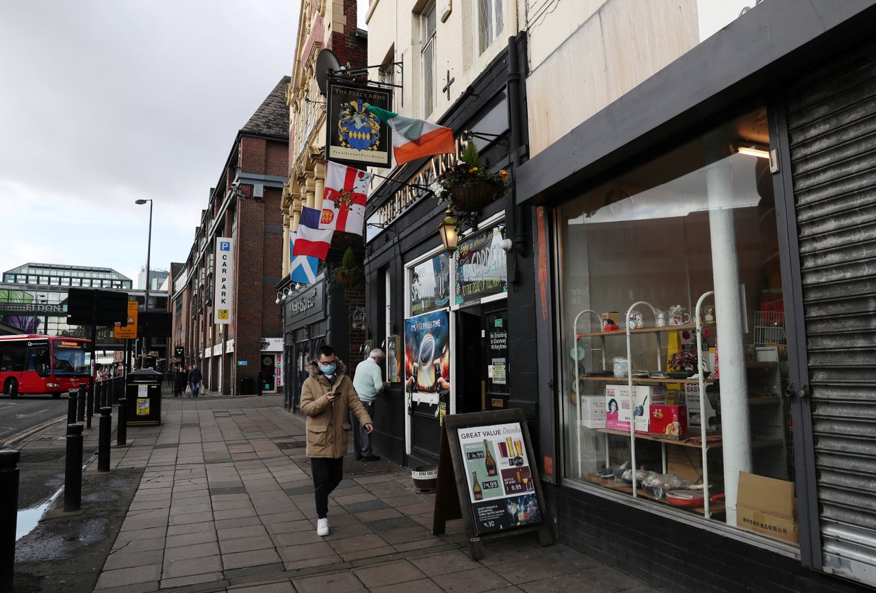 A general view as a man wearing a protective face mask walks past the Percy Arms pub, Newcastle 