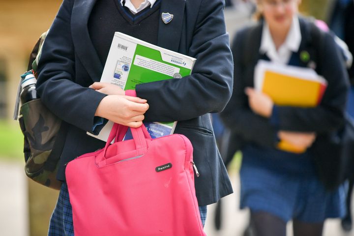 School pupils holding bags and books 