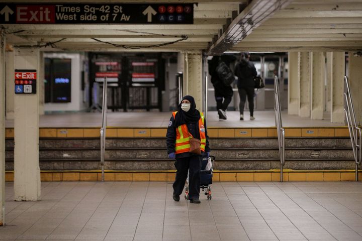 An MTA transit worker walks through a nearly empty Times Square - 42nd St. subway station during the morning rush in New York, U.S., March 16, 2020. REUTERS/Brendan McDermid
