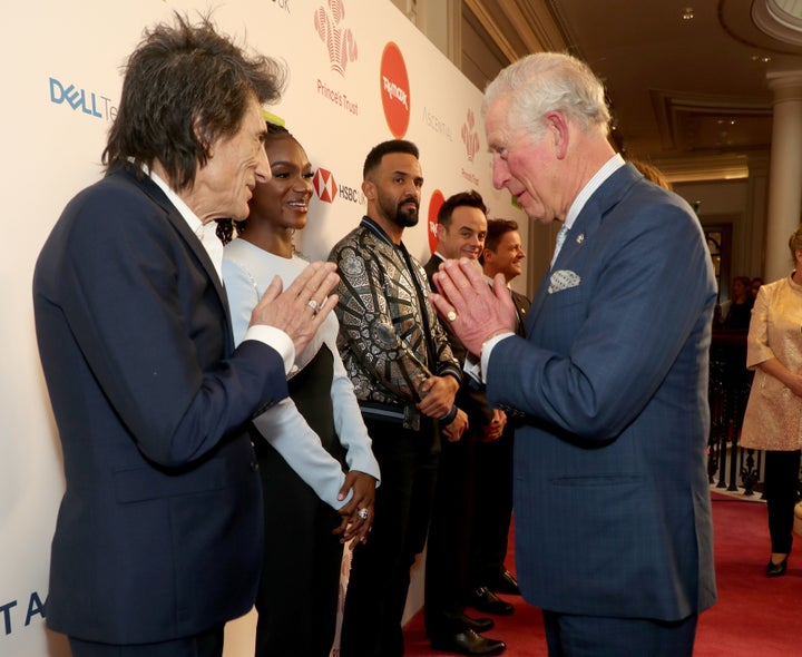 Charles uses a Namaste gesture to greet Rolling Stone Ronnie Wood as he attends the Prince's Trust and TK Maxx & Homesense Awards at London Palladium on March 11 in London. 