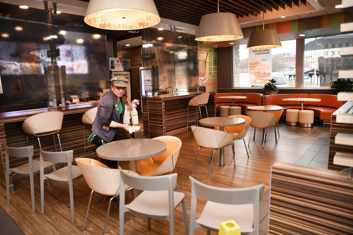 Lori Harper, manager, wipes down tables in the dining room area of the McDonald's on Prince Street in Beckley Tuesday morning