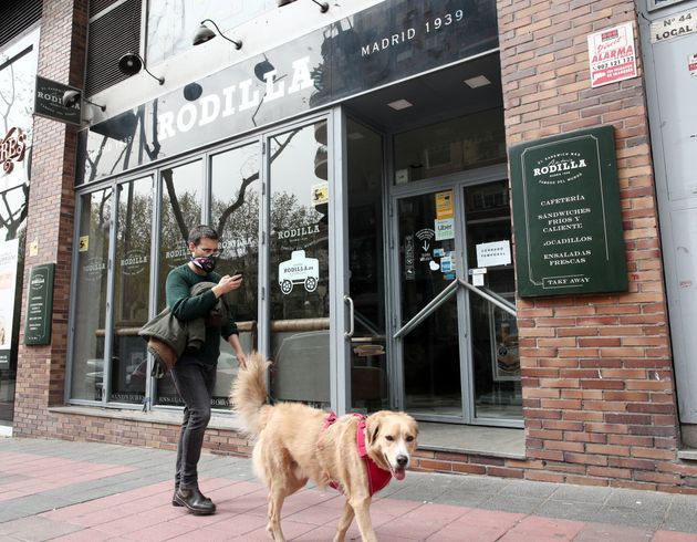 A man with a mask and his dog take a walk in Madrid, Spain, on Wednesday.