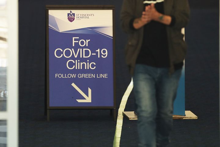 People pass signs for a COVID -19 Clinic at St Vincent's hospital on March 18, 2020 in Sydney, Australia.