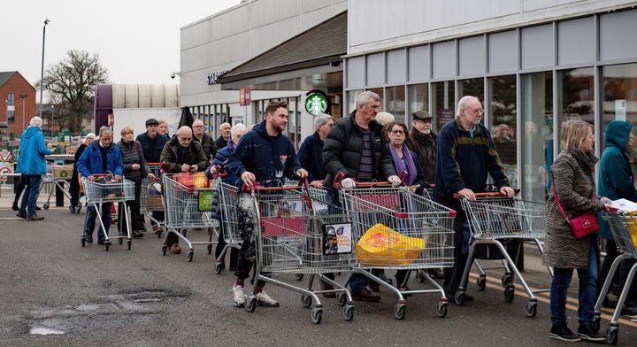 People queue to shop at Sainsbury's supermarket in Leamington Spa, Warwickshire, where the store had announced that the first hour of opening would be for elderly and vulnerable customers.
