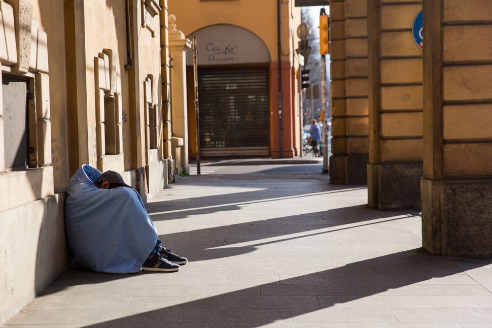 A homeless person sleeping under porches in Bologna during Italy's quarantine.