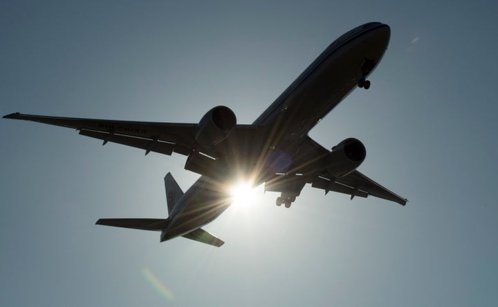 A Southern China Airlines flight flies past the sun as it arrives at Vancouver International Airport on March 18, 2020.