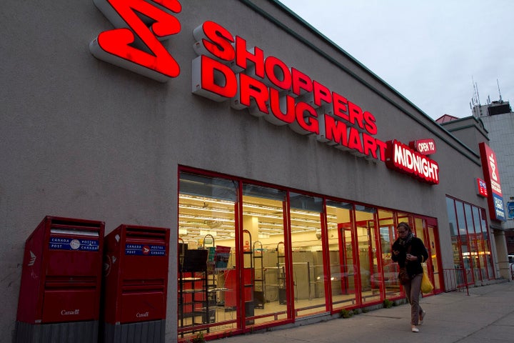 In this file photo, a woman walks in front of a Shoppers Drug Mart in Kingston, Ont., Mon. April 30, 2012.