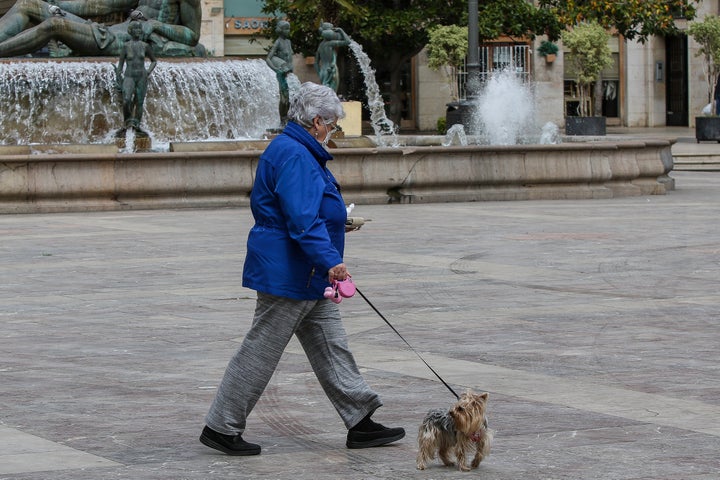 A woman walks her dog in Valencia, Spain. Experts say going for walks is safe, as long as you're not getting too close to people.