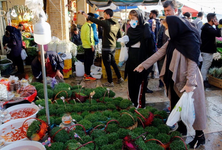 Iranians, some wearing protective face masks, shop at a bazaar ahead of Nowruz in the capital Tehran on March 19, 2020.