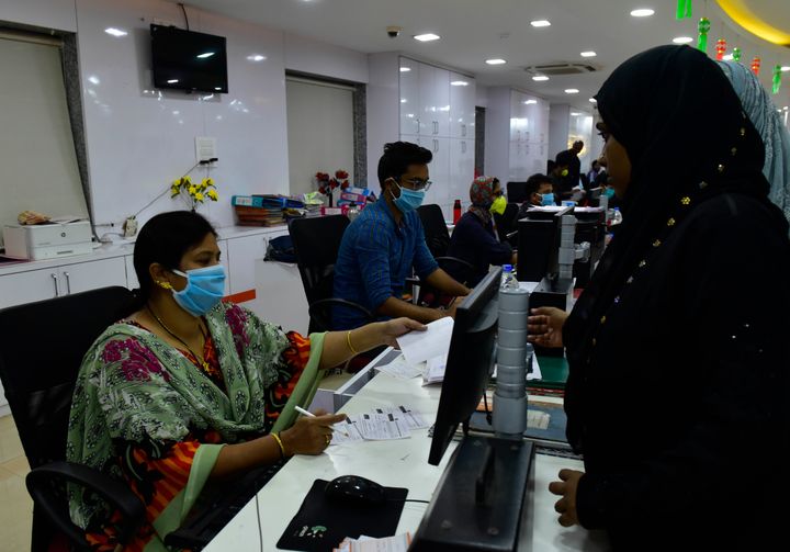 MStaff of Bank of Baroda wear protective mask while working in bank at Byculla because of Corona pandemic, on March 17, 2020 in Mumbai.