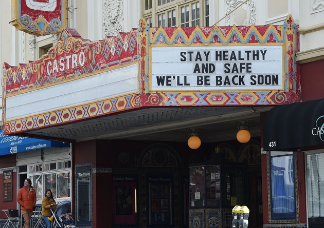 A couple walks by the Castro theater with their baby in San Francisco, California on March 17,