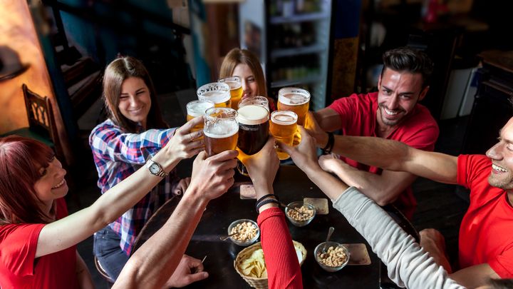 A group of people celebrating in a pub drinking beer and eating snacks - an activity the prime minister has said should temporarily stop.