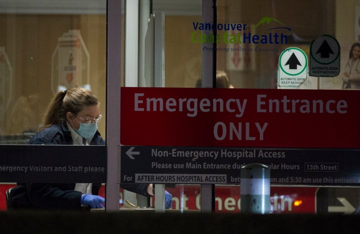 A hospital worker at the entrance of the emergency department at a Vancouver hospital on March 18, 2020. 