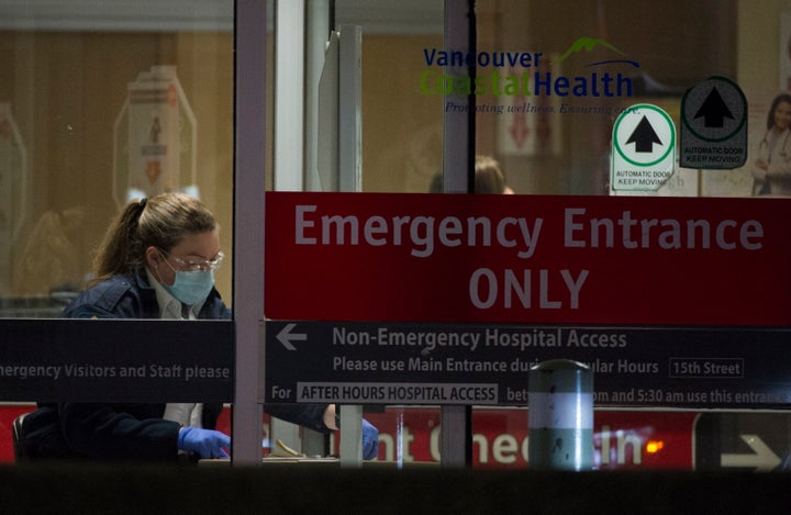 A hospital worker at the entrance of the emergency department at a Vancouver hospital on March 18, 2020. 