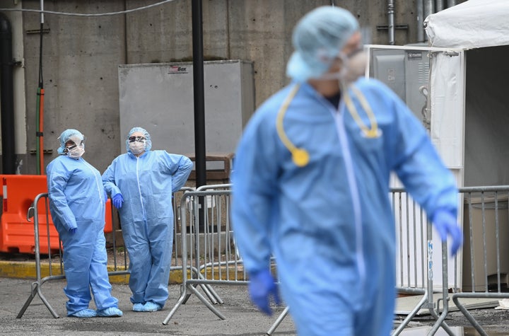 Medical staff stand outside a coronavirus screening tent at the Brooklyn Hospital Center on Friday in Brooklyn, New York.