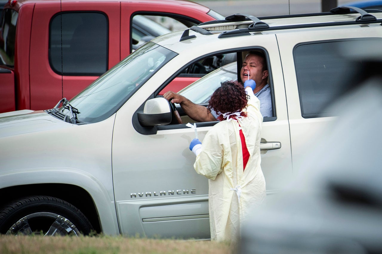 A drive-through patient has his nose swabbed by staff during a screening at Waddell Family Medicine as Athens-Limestone Hospital opens a flu and fever clinic Thursday in Athens, Ala. Patients will only be tested for COVID-19 if indicated by their exam or ordered by a physician or provider.