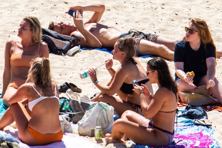 People are seen sitting close together at Bondi Beach on March 20, 2020 in Sydney, Australia. 