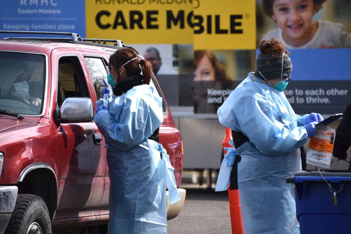 Critical care nurse Molly Spaeny, left, with St. Vincent Healthcare speaks with a patient after administering a coronavirus test in a drive-thru testing center outside the hospital in Billings, Mont. Friday, March 20, 2020. 