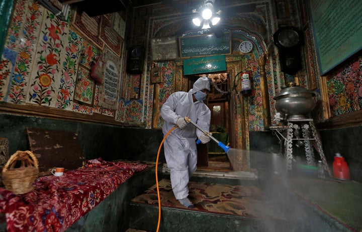 A municipal worker wearing a protective suit disinfects the shrine of Sufi Saint Khawaja Naqashband as a preventive measure against the spread of coronavirus disease (COVID-19), in Srinagar March 19, 2020.