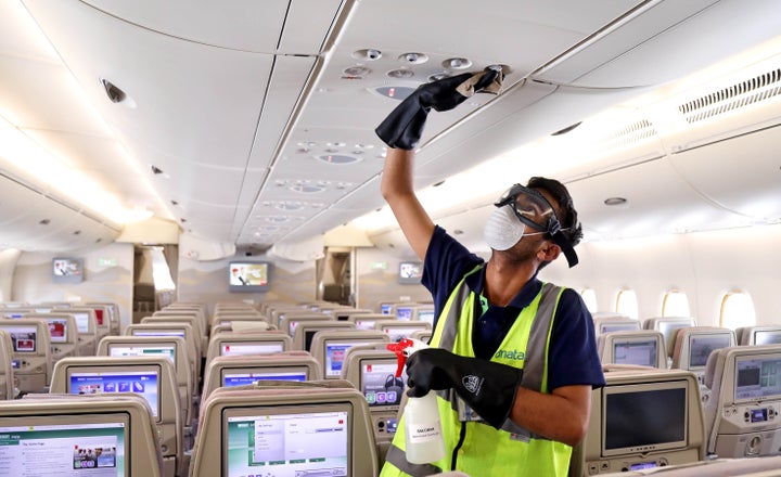 A member of cleaning staff wearing protective mask disinfects air vents of an Emirates Airbus A380 in Dubai, United Arab Emirates, on March 5.